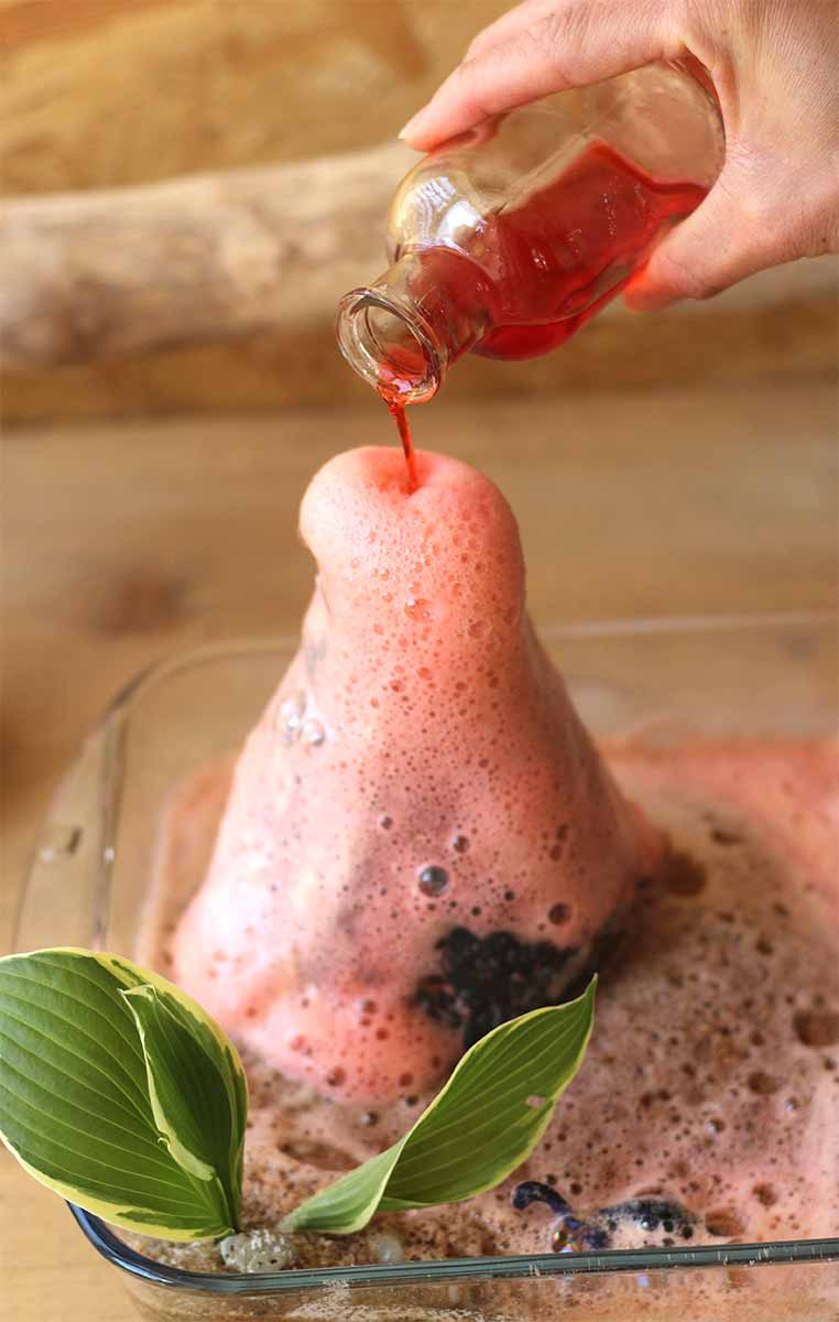 Experiment für Kinder und Erwachsene: Ein Vulkanausbruch mit Zitronensäure und Soda. Die Flüssigkeit wurde mit Lebensmittelfarbe rot eingefärbt.